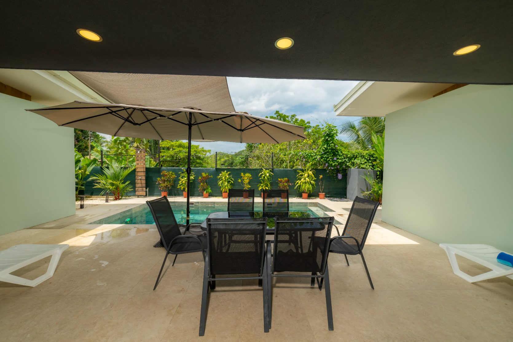 Terraza techada, comedor exterior y piscina privada de Casa Tatala